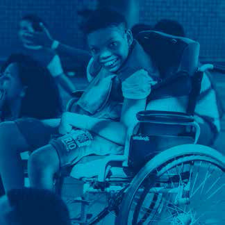 2015: menino em cadeira de rodas sorri.