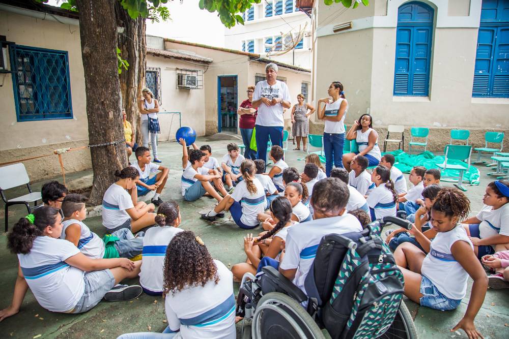 Crianças e professores reunidos no pátio da escola.